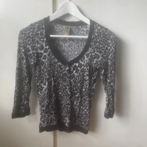 Leopardmönstrad kofta från Bershka - Säljer en snygg leopardmönstrad kofta från Bershka med svarta kanter och knappar framtill. Koftan har trekvartsärm och är i mjukt material. Den är ganska liten i storleken så skulle säga att den passar s, xs mer!💕