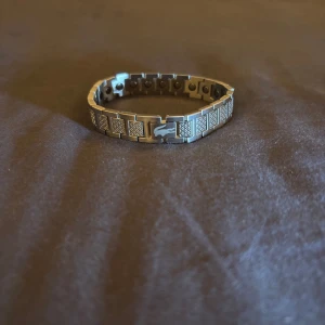 Lacoste armband silver - Oanvänt Lacoste armabd. Väldigt fint och passar bra som smycke på handleden. Den är 20cm lång 