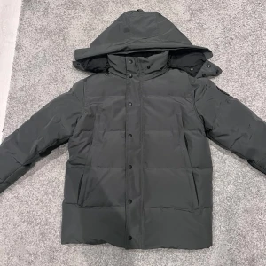 jacka från Canada Goose - Jag säljer min canada goose jacka i färgen grå. Jag säljer den då jag inte använder den längre och för att jag har fått en ny. Jackan är i storlek M. Den är perfekt för vintern och de kalla tiderna som vi väntar oss