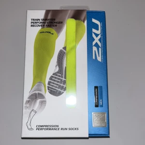 2XU gula kompressionsstrumpor L - Säljer ett par 2XU kompressionsstrumpor i storlek L. De är knähöga och har en riktigt skarp gul färg. Perfekta för löpning eller träning, tillverkade i nylon och elastan för bästa passform och andningsförmåga. Snygg 2XU-logga upptill.