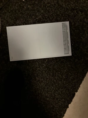 Xbox Series S - Xbox Series S i vitt utförande. Kompakt och modern design med synliga portar och kylning. Konsolen ser ut att vara i gott skick med endast mindre tecken på normalt bruk. Perfekt för dig som vill spela de senaste spelen digitalt. Strömkabel medföljer.