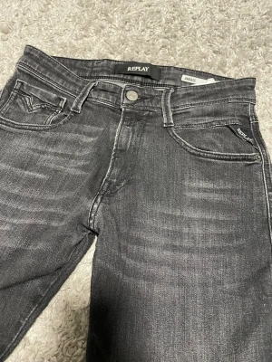 Replay Anbass svarta slim jeans - Svarta Replay Anbass jeans i slim fit med snygga slitningar och klassisk femficksdesign. Jeansen har tydliga Replay-detaljer och är tillverkade i stretchig denim för en bekväm passform. Perfekta för dig som gillar en smal siluett och stilren look. Kan gå ner i pris vid snabb affär. Använda fåtal gånger. MVH Isak