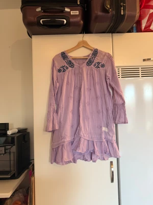 Odd mllly tunika  - Säljer en otroligt vacker lila tunika med lila broderade detaljer. Tunikan har även mörkblå broderade detaljer vid axeln och runt halsen. Från märket Odd Molly. Storlek 2 som enligt deras storleksguide motsvarar en M. Mycket fint skick, jag hittar inga synliga anmärkningar eller defekter. 