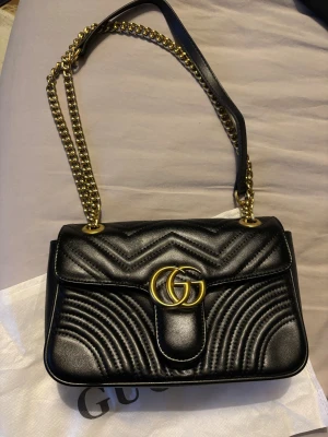 Snygg axelväska  - Helt ny svart väska med guld detaljer 