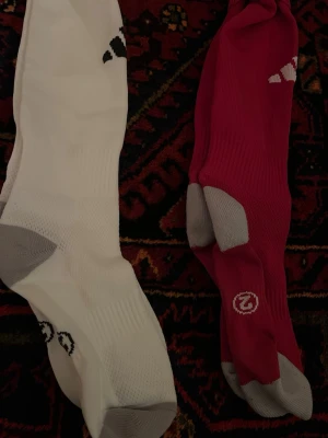 Adidas fotbollsstrumpor vit & röd - Säljer två par fotbollsstrumpor, aldrig använda, storlek 2, adidas