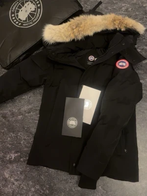 Svart dunjacka från Canada Goose - Säljer en svart dunjacka från Canada Goose. Helt ny aldrig använd. Perfekt nu inför kalla dagar, riktigt fint passform är äkta.