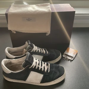 Svarta Valentino Flycrews - Säljer ett par snygga Valentino Flycrews med vit snörning! Självklart kommer originalsnören med! Allt og ingår (dustbag, skolåda). Till skorna får du även med ett packet med 100 nitar!😮‍💨Storlek 41 men passar även 42! På bilden ser du även vissa defekter som på sulan till exempel, de har även ett litet hål på högerskon vid tån men det är inget som syns eller märks av vid användning!👌 Kom gärna med fler frågor👑