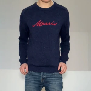 Marinblå Morris tröja - Säljer en sjukt fet mörkblå tröja från Morris med rött tryck framtill. Strl M och sitter som M. Tröjan är i bra skick förutom en liten tråddragning längst ner i hörnet som kan klippas av och inte syns vid användning. Hör gärna av er vid frågor eller funderingar!!