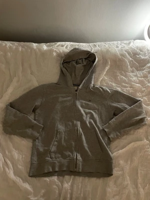 Två Gant Zip Hoodies - Jag säljer nu en grå och en blå gant zip hoodie. Båda är i storlek 158/164. Den blåa är i väldigt bra skick och endast använd ett fåtal gånger, men den gråa är inte i lika bra skick. Som ni ser på bilden har tröjan ett litet hål vid ärm mudden. Annars har den inga fler synliga skador. Därför kostar den blåa 299 kr och den gråa 149 kr. Vid fler frågor och funderingar kan ni kontakta mig! 