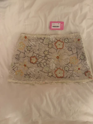 Minikjol från Edikted - Minikjol från edikted med paljetter och ”beads” som tyvärr var för stor på mig. Helt ny med lappen kvar. Obs! Dragkedjan är lite trög.  Försöker bli av med så mycket som möjligt så kika gärna in mina andra plagg 😊