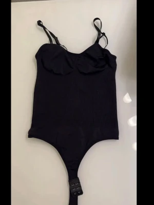 Svart bodysuit med justerbara axelband - Oanvänd svart body, storlek S mer som en XS eftersom det är en tight modell