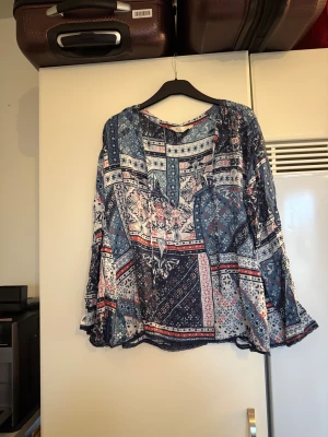 Odd molly blus  - Säljer en otroligt vacker blå blus med ett superfint mönster i bland annat vitt, rött och olika nyans av blått. Från märket Odd Molly. Storlek 2 som enligt deras storleksguide motsvarar en M. Mycket fint skick, jag hittar inga synliga anmärkningar eller defekter. 