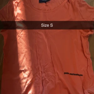 Orange t-shirt från Peak Performance - Säljer en orange t-shirt från Peak Performance i storlek S. Klassisk rund halsringning och korta ärmar. Diskret logga tryckt nere på framsidan. Perfekt för en sportig och avslappnad stil.