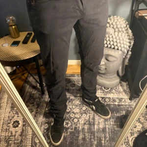 Svarta slim fit superstretch byxor - Svarta byxor i slim fit-modell med superstretch för extra komfort. Byxorna har klassisk femficksdesign och dragkedja i gylfen. Snygg och stilren look som passar perfekt till sneakers. Tillverkade i ett stretchigt material för en modern passform.