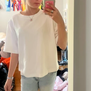 Vit oversized t-shirt från 157 - Säljer en vit t-shirt från 157 i oversized modell. T-shirten har rund halsringning och korta ärmar, tillverkad i mjuk bomull. Perfekt basic-plagg att styla med jeans eller shorts.