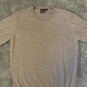 Merinoulls tröja från Oscar Jacobson - En beige merinoulls tröja från Oscar Jacobson perfekt nu inför vintern. Nypris 1399kr