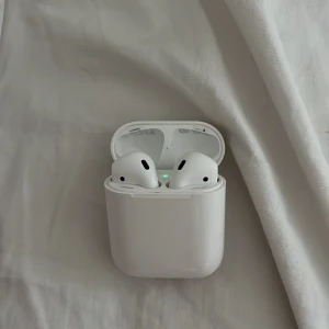 Apple AirPods (2nd Generation) - Säljer ett par Apple AirPods (2nd Gen) med original laddningsetui. Hörlurarna är i gott skick med endast mindre ytliga defekter på insidan skalet! Försökt skrubba bort men de har inte försvunnit. Pris kan diskuteras!