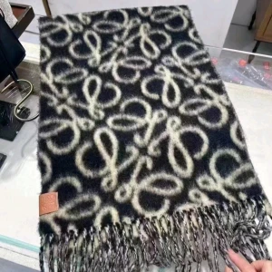 Svart och vit ullhalsduk  - Snygg svart och vit halsduk  med ikoniskt mönster och långa fransar. Tillverkad i mjuk ull som håller dig varm och ger en lyxig känsla. Perfekt accessoar för att lyfta din outfit med en trendig touch.