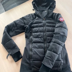 Svart dunjacka från Canada Goose - Jag kollar intresse för min Canada Goose HyBridge Sutton-jacka! Sömmen har kommit upp lite längst ner på båda ärmarna, den kan sys ihop. Annars är den i bra skick!☺️ 