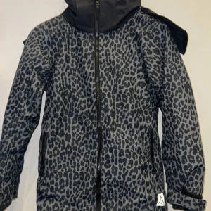 Leopardmönstrat skidsätt  - Snygga täckbyxor med grått och svart leopardmönster. Byxorna har dragkedjor vid fickorna och stängs med knapp och kardborre i midjan. Perfekta för vintern och riktigt coola att bära i backen.