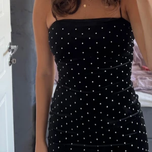 Svart prickig sammetsklänning - Supersnygg svart sammetsklänning med tunna axelband och silvriga prickar över hela klänningen. 