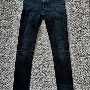 Svarta jeansbyxor från Nudie Jeans - Säljer ett par svarta jeansbyxor från Nudie Jeans. Modell: Skinny Lin. Jeansen är enbart använda 2 - 3 gånger, och har inga tecken på användning. Skick: 10/10. Passar någon som är 166 - 178. Om ni har några fler frågor eller vill ha fler bilder så är det bara att kontakta mig!