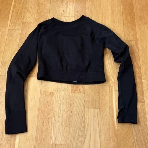 Svart croppad långärmad träningstopp - Svart träningströja med ”mönster” på ryggen!