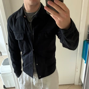 Mörkblå overshirt från Denimes, stl S - Mörkblå overshirt från Denimes i bomull med klassisk krage, bröstfickor med lock och knäppning framtill. Snygg och enkel modell som passar perfekt till lager-på-lager. Långärmad och i en normal passform. Sitter bra, passar även XS