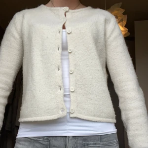 Vit kofta från Gina Tricot i ullmix - Supermjuk och fluffig vit kofta från Gina Tricot i ullblandning. Klassisk rak modell med rund halsringning och knappar framtill. Perfekt att slänga över ett linne eller t-shirt för en chill look. Långärmad och riktigt cozy vibe.