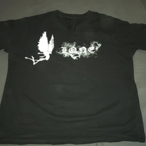 Svart Vlone t-shirt - Svart t-shirt från Vlone med stor vit rökig V på ryggen och tryck med texten lone och med en ängel 