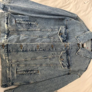 Ljusblå jeansjacka från Zara XS - Säljer en klassisk ljusblå jeansjacka från Zara i storlek XS. Jackan har raka linjer, knäppning med metallknappar framtill, två bröstfickor med lock och två sidofickor. Perfekt oversized känsla och snygg tvättad denim-look.
