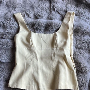 Ljusgul topp från HM💛 - Säljer en ljusgul linnetopp från H&M Divided i storlek S. Toppen har breda axelband och figurnära passform med sömdetaljer framtill. Använd ca 3 gånger.