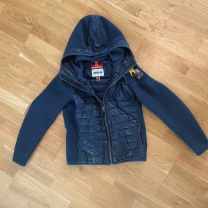 Parajumper cardigan  - Säljer en blå parajumper cardigan som jag     köpte ifrån kidsbrandstore . Jackan är storlek 150/158 men den passar upp till 162 . Jag hade den tills jag var cirka 163 . Den har inga defekter och är i ganska bra skick , en 8/10 .  NYPRIS  3500-4500 . 