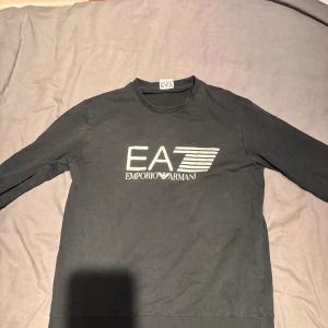 EA7 svart S/M - Svart långärmad tröja från EA7 Emporio Armani med EA7 logga framtill. Inga tecken på slitage alls och tröjan är riktigt stilren och passar till det mesta. Bara att fråga vid minsta fundering😃👍🏼