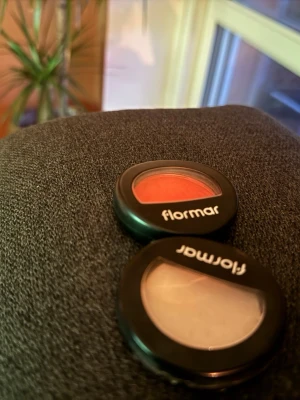 Flormar rouge och highlighter duo - Två sminkprodukter från Flormar: ett persikofärgat rouge och en ljus, skimrande highlighter. Båda kommer i rund, svart plastförpackning med transparent lock. Perfekt för att ge kinderna färg och glow. Swatches visar tydlig pigmentering och fin finish.