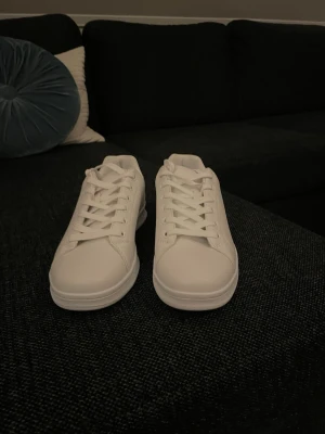 Helvita sneakers med snörning - Säljer ett par fräscha helvita sneakers med klassisk rund tå och platt sula. Aldrig använda, inte hugget i sten🤝