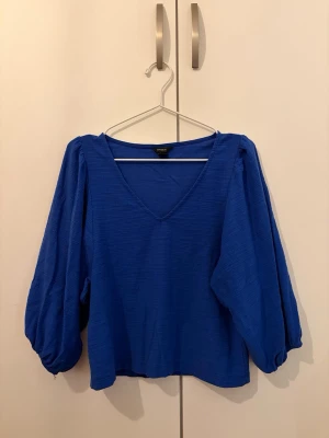 Lindex - V-ringad topp med puffiga trekvartsarmar. 