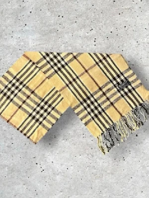 Beige Burberry halsduk - Säljer en snygg Burberry halsduk i den klassiska beige färgen med det välkända rutmönstret. Tillverkad i 100% mjuk och värmande ull.   🧵 Skick: Mycket fint skick, väl omhändertagen 🌟 Känsla: Mjuk, varm och följsam 📦 Frakt: Skickas tryggt inom 24h 📏 Mått: Längd-140cm, Bredd-29cm  Pris kan diskuteras!