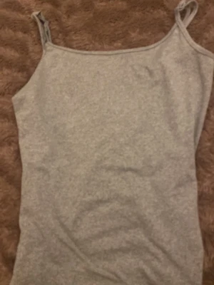 Grå linnetopp  - Grått linne med smala Axel band som går att justera. Jag skulle säga att storleken är Xs-S. Den är jätte fin som att ha som ett bas plagg