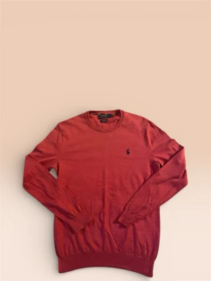 Röd tröja från Polo Ralph Lauren - Snygg röd långärmad tröja från Polo Ralph Lauren i slim fit. Tröjan är tillverkad i mjuk Pima bomull och har en rund hals samt den klassiska broderade loggan på bröstet. Perfekt för dig som gillar stilrena och bekväma plagg. 100 % äkta.