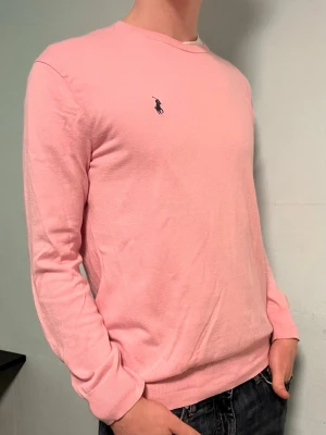 Rosa stickad tröja Polo Ralph Lauren - Säljer denna snygga rosa tröja från Ralph Lauren i prima cotton (väldigt fin bomull). Den är i väldigt fint skick, men värt att notera är att den är lite nopprig. Hör gärna av dig om du har några frågor!  Allt gott, Deluxe Garderoben 🤩 