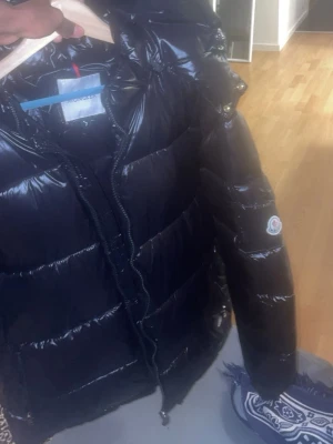 Svart pufferjacka från Moncler - Allt i jackan är som den ska vara inget fel och man kan skannet fungerar bra på jackan.