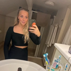 Svart set med långkjol - Svart croppad topp från Boohoo med lång ärm och fyrkantig halsringning. Samt en långkjol (ner till fötterna) i tajt modell.  Snygg och stilren design som visar lite midja. Tunn och stretchig polyester som sitter skönt och följer kroppen. Från Boohoo