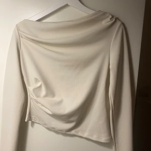 Krämvit långärmad topp Gina Tricot - Säljer en stilren krämvit långärmad topp från Gina Tricot i storlek S. 