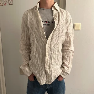 Beige randig linneskjorta  - The glory Days skjorta i Ny skick storlek S,37-38. Killen på bilden 180, 65kg. Skriv vid funderingar. Allt gott! 