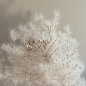 Glittrig guldring med zickzack-design - Snygg guldfärgad ring med zickzack-form och glittriga små stenar längs hela mönstret. Perfekt för dig som gillar unika detaljer och vill sticka ut med ditt smycke. Ringen har en modern och trendig look som passar till många stilar.