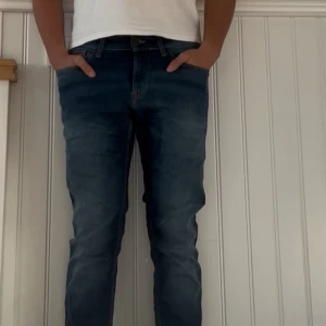 Mörkblå Tommy hilfigger jeans  - Snygga mörkblå jeans med klassisk femficksdesign och lätt tvättade detaljer. Jeansen har en tapered passform som smalnar av nedtill och sitter skönt över benen. Perfekta för dig som gillar en modern men avslappnad stil. Storlek 31:32
