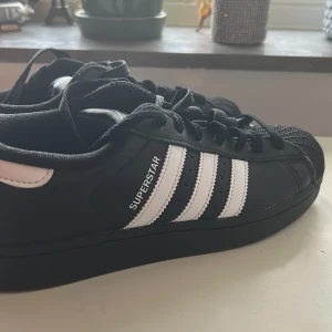 Adidas Superstar svarta sneakers 42 - Säljer dessa jag köpte för en gångs användning. Har ej använt de mer än så. Så gott som nya. Köpt för en månad sen från JD sports i Skärholmen. 