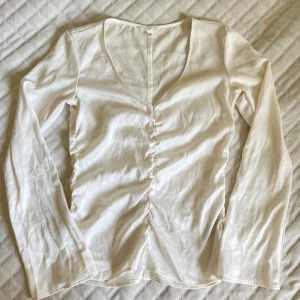 Vit/cremevit v-ringad volangblus HM - Använd några få gånger (ca 2-3)  Ärmen blir bredare/utsvängd längre ner mot handleden. Silkesliknande i materialet  98% POLYESTER  2% ELASTAN   PS: Kolla in mina andra annonser, upp till 20% rabatt vid köp av flera artiklar och priset går nästan alltid att diskutera!🩷    