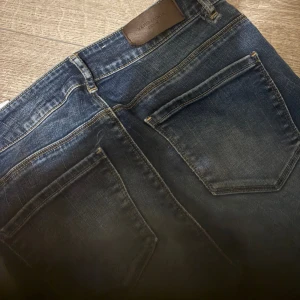 Blå raka jeans från Vero Moda - Snygga blå jeans från Vero Moda med rak fit och klassisk femficksdesign. Jeansen har hög midja och är tillverkade i stretchigt denimmaterial som sitter tajt och bekvämt. Perfekt för dig som gillar en smal siluett och cool tvätt.